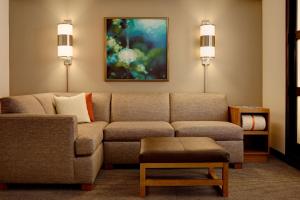 a living room with a couch and a painting at Hyatt Place Orlando Airport in Orlando