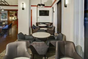 a waiting room with tables and chairs at Hyatt Place Memphis Primacy Parkway in Memphis