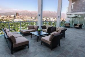 uma varanda com sofás e mesas e vista para a cidade em Hyatt Place Santiago/Vitacura em Santiago
