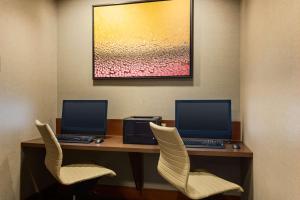 2 ordinateurs sur un bureau avec 2 chaises dans l'établissement Hyatt Place Seattle Downtown, à Seattle