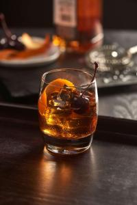 a glass of alcohol with a drink and fruit at Hyatt House Naples 5th Avenue in Naples