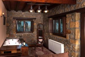 カト・トリカラ・コリンティアスにあるPera Alonia Guest Houseのバスルーム(バスタブ、テーブル、椅子付)