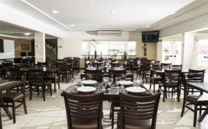 a dining room filled with tables and chairs at Hotel Imperador in Salgueiro