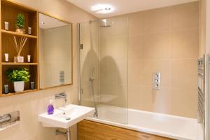 y baño con lavabo y ducha. en Penthouse 5 mins walk to City Centre & Colleges with Balcony & Sleeps 6 en Cambridge