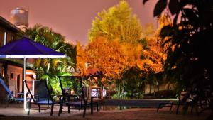 a group of chairs and an umbrella next to a pool at marangatu apart hotel in Puerto Iguazú