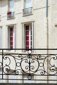 - un balcon dans un bâtiment avec deux fenêtres dans l'établissement L'Argenterie, Apparts de charme climatisé parking gratuit, à Montpellier