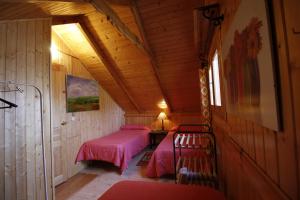 a bedroom with two beds in a wooden cabin at El Paso de las Cigüeñas in Candeleda +54 photos