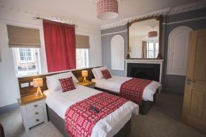 a bedroom with two beds and a fireplace at Ty Castell in Caernarfon
