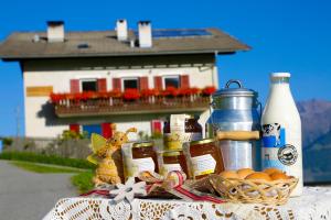a table with a basket of food and a house at Bauernhof Mairing in Silandro