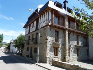 a brick building with a balcony on a street at Hotel Esther in La Virgen de la Vega