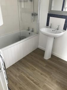 a bathroom with a sink and a bath tub and a sink at Old Vicarage Mortehoe Near Woolacombe 2 x sleeps 4 and 1 x sleeps 10 cottages in Mortehoe