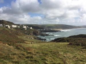 a view of the ocean with houses on a hill at Old Vicarage Mortehoe Near Woolacombe 2 x sleeps 4 and 1 x sleeps 10 cottages in Mortehoe