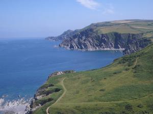 a green hillside with a view of the ocean at Old Vicarage Mortehoe Near Woolacombe 2 x sleeps 4 and 1 x sleeps 10 cottages in Mortehoe