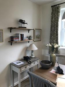 a room with a desk and a table with a lamp at Old Vicarage Mortehoe Near Woolacombe 2 x sleeps 4 and 1 x sleeps 10 cottages in Mortehoe