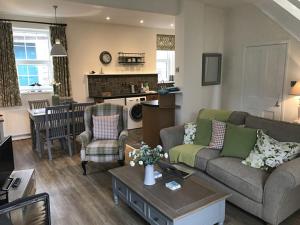 a living room with a couch and a table at Old Vicarage Mortehoe Near Woolacombe 2 x sleeps 4 and 1 x sleeps 10 cottages in Mortehoe