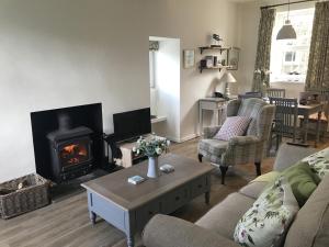 a living room with a couch and a fireplace at Old Vicarage Mortehoe Near Woolacombe 2 x sleeps 4 and 1 x sleeps 10 cottages in Mortehoe