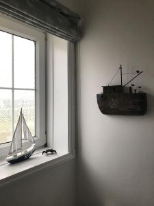 a toy boat sitting on a window sill at Old Vicarage Mortehoe Near Woolacombe 2 x sleeps 4 and 1 x sleeps 10 cottages in Mortehoe
