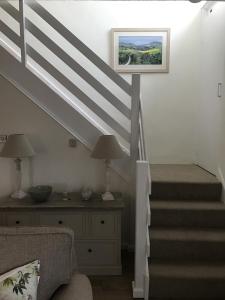 a living room with stairs and a picture on the wall at Old Vicarage Mortehoe Near Woolacombe 2 x sleeps 4 and 1 x sleeps 10 cottages in Mortehoe