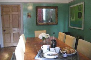a dining room table with a plate of food on it at Old Vicarage Mortehoe Near Woolacombe 2 x sleeps 4 and 1 x sleeps 10 cottages in Mortehoe