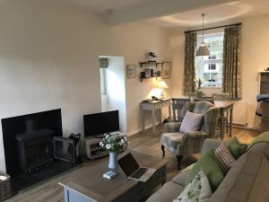 a living room with a couch and a fireplace at Old Vicarage Mortehoe Near Woolacombe 2 x sleeps 4 and 1 x sleeps 10 cottages in Mortehoe