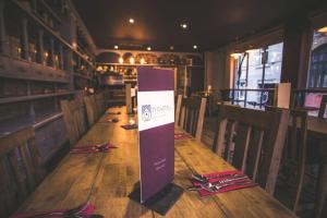 a wooden table in a restaurant with a sign on it at Ty Castell in Caernarfon