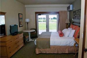 a hotel room with a bed and a television at Homestead Resort in Lynden