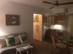 a living room with a couch and a table and a kitchen at Villa L'Amiraute in Agde
