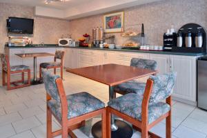 uma cozinha com uma mesa de madeira e cadeiras em Lexington Inn & Suites-Windsor em Windsor