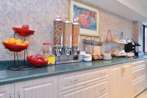 a kitchen with a counter with bowls of fruit on it at Lexington Inn & Suites-Windsor in Windsor