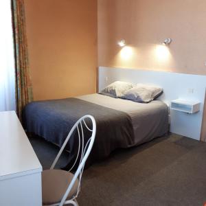 1 dormitorio con 1 cama y 1 silla en Le Saint Christophe en Cosne Cours sur Loire