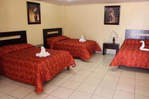 a hotel room with three beds with white swans on them at Hotel Conquistadores in Zacatecas +16 photos