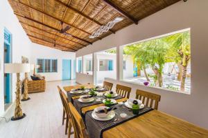 a dining room with a wooden table and chairs at Villa Rosa Maldives in Feridhoo