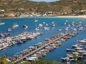 a bunch of boats are docked in a harbor at Ressurgência loft in Arraial do Cabo