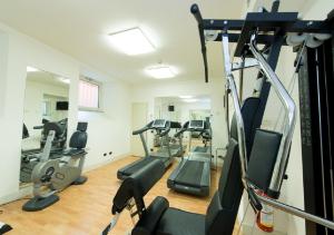 a gym with treadmills and ellipticals in a room at Hotel Bellagio in Bellagio