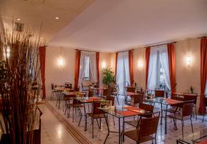 una sala da pranzo con tavoli, sedie e finestre di Hotel Bellagio a Bellagio