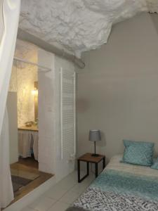 a bedroom with a bed and a table with a lamp at Gîte en Touraine in Luynes