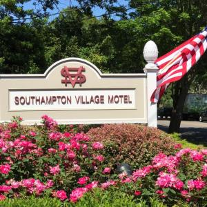 a sign for the southcolm village motel with pink flowers at Southampton Village Motel in Southampton