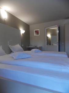 1 cama blanca grande en una habitación con espejo en Pensiune Xe-Mar en Arad