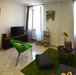 a living room with a green chair and a television at Heart of the city app in Rijeka
