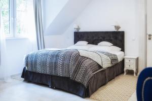 a bedroom with a large bed with a black headboard at Martiany 21 in Martiany +79 photos