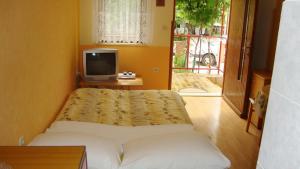 a bedroom with a bed and a tv and a window at Apartments Pero in Pula