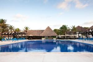 una piscina en un complejo con sillas azules y palmeras en Allegro Playacar - All Inclusive Resort, en Playa del Carmen