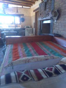 a bedroom with a bed with a colorful blanket on it at Hogar de Campo in San Rafael