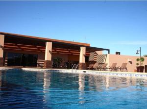 a building with a swimming pool in front of it at Hotel Gandara in Hermosillo