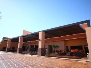 a building with a patio with couches and tables at Hotel Gandara in Hermosillo