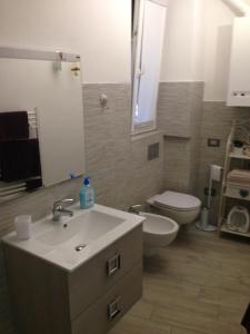 La salle de bains est pourvue d'un lavabo blanc et de toilettes. dans l'établissement La Casa del Cuore, à Lerici