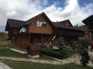 a large wooden house with at Guesthouse Kolo Druziv in Tatariv