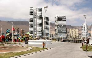 uma cidade com edifícios altos e um parque infantil no primeiro plano em Iquique Playa Brava 1670 em Iquique