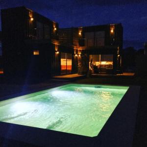 a swimming pool at night in front of a house at Pretas in Punta Del Diablo