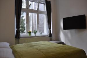 a bedroom with a bed and a window with a television at Studio Apartments City&style in Zagreb